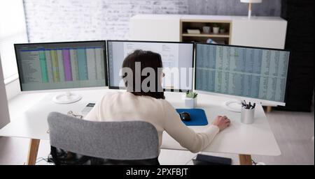 Using Corporate Invoice Spreadsheet On Computer Monitors Stock Photo