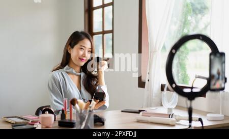 Beauty blogger using brush with powder to applying product for reviewing cosmetic in makeup vlogger. Stock Photo