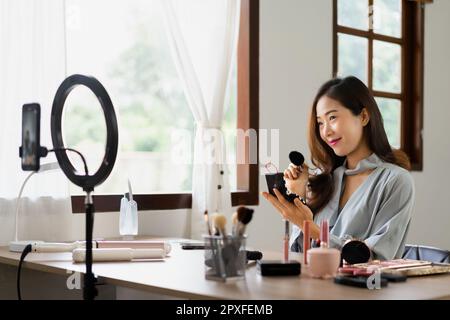 Beauty blogger use brush with blush on to applying product for reviewing cosmetic in makeup vlogger. Stock Photo