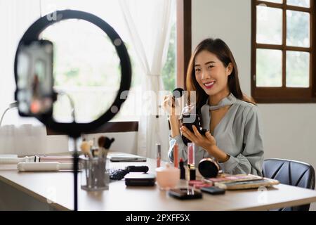 Beauty blogger use brush with blush on to applying product for reviewing cosmetic in makeup vlogger. Stock Photo