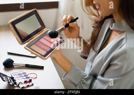 Beauty blogger use brush with blush on to applying product for reviewing cosmetic in makeup vlogger. Stock Photo