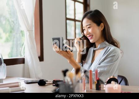 Beauty blogger using brush with powder to applying product for reviewing cosmetic in makeup vlogger. Stock Photo