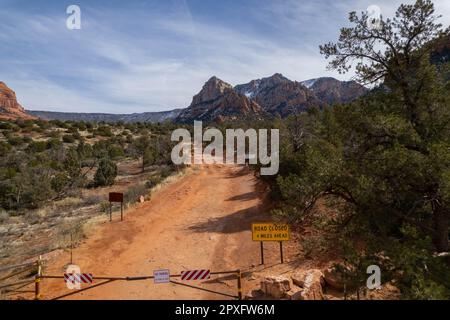 A picturesque orange dirt road meanders through a vibrant valley with Schnebly Hill in the background Stock Photo