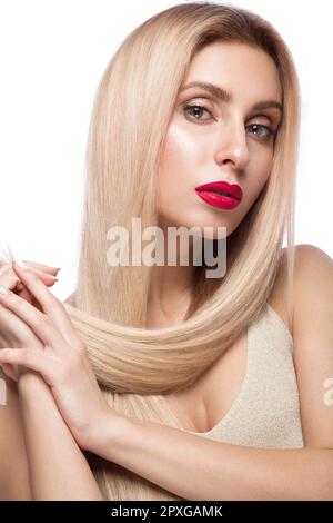 Beautiful blond girl with a perfectly smooth hair, and classic make-up. Beauty face. Picture taken in the studio. Stock Photo