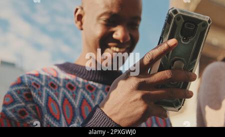 Close-up of the hands of a young man using a mobile phone Stock Photo