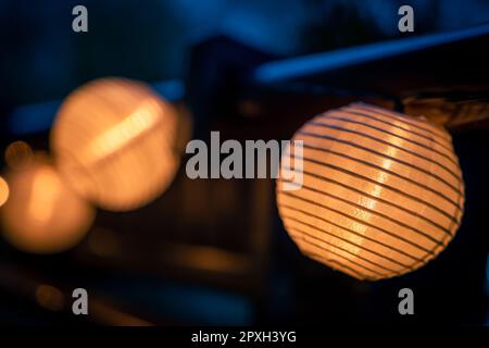 A lighted garland with solar lamps hung on the balustrade of the balcony. Mood light. Evening Stock Photo