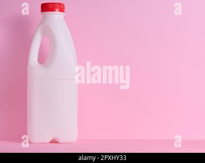 White plastic bottle for milk and dairy products on a pink background Stock Photo