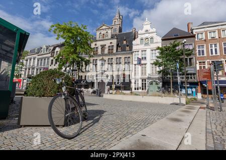 Shops, bars, cafes, offices in cobbled Korenmarkt with gabled houses and bicycle, Mechelen, Belgium Stock Photo