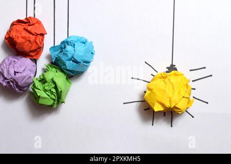 Creative thinking ideas and innovation concept. Paper scrap ball yellow colour with light bulb symbol Stock Photo