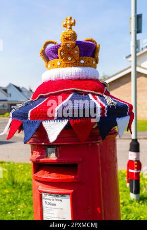 Poole, Dorset, UK. 2nd May 2023. A knitted crocheted postbox topper for the Coronation of King Charles III appears on a red post box together with a soldier guardsman around a lamppost keeping watch in Poole, Dorset.  - post box topper, letterbox topper, letter box topper, toppers, yarn bombing, yarn bomb. Credit: Carolyn Jenkins/Alamy Live News Stock Photo