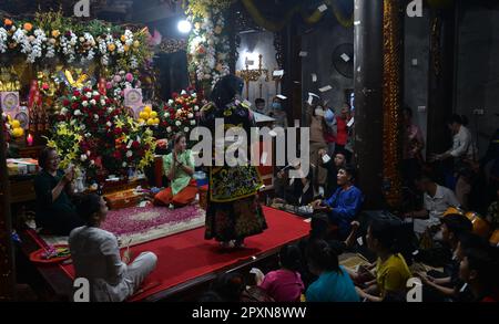 Shaman plays the role of a god performing rituals to transmit messages in Mother Goddess Worship event. North Vietnam. hầu đồng. 越南旅游, 베트남 관광, ベトナム観光 Stock Photo