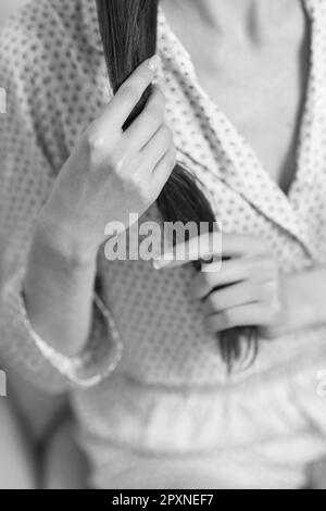 female hands hold long smooth hair. black and white Stock Photo