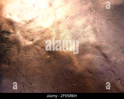 Metal bronze textured plate. Bronze or copper polished surface with dents, scratches and indentations. Metal texture. Stock Photo