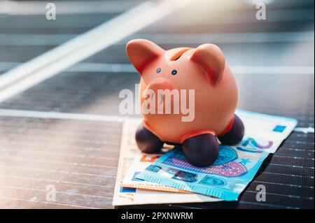 Money saved by using clean energy with solar panel Stock Photo