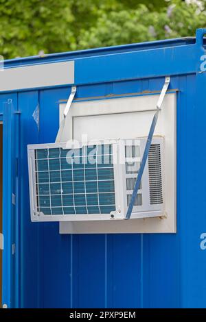 Window Mounted Air Conditioner Unit at Converted Cargo Container Temporary Office Stock Photo