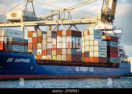 Rotterdam, Netherlands - November 22 2021 : pile of containers on the deck of a container ship ready to be offloaded by huge cranes Stock Photo