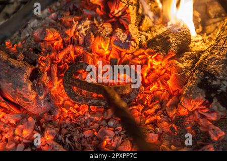 Heating branding iron for cattle over embers. Selective focus Stock Photo