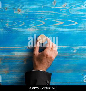 Hand of a businessman placing a wooden cut circle with an AI sign on it over textured blue background. Conceptual image of Artificial inteligence and Stock Photo