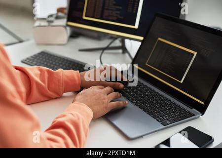 Close-up of programmer writing code for on laptop for software while working at workplace in office Stock Photo