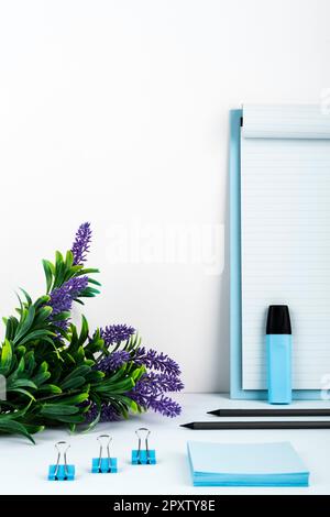 Pot with Plant and Cup Standing on Desk. Iinfrormation written on paper. Stock Photo