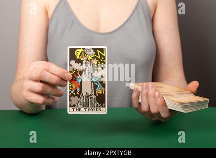 Lodz Poland April 15 2023 The Tower arcana, hand holding showing tarot card during divination. Stock Photo