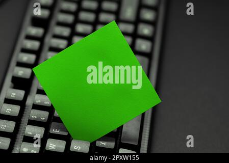 Colored sticker lying on keyboard. Important message written over paper. Stock Photo