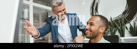 Two multiethnic business colleagues working together in modern office Stock Photo