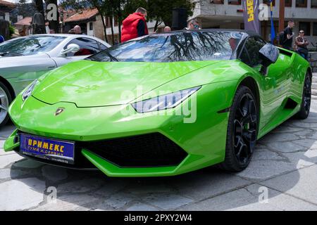 Green Laborghini parked side by side with Mercedes SLR on a paved road in a residential area Stock Photo