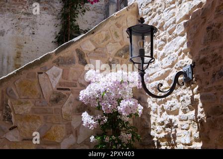 a wrought iron lantern on a stone wall in an Italian farmhouse Stock Photo