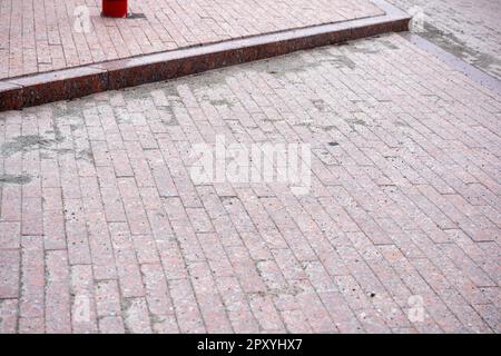 Red colored paving stones are laid on the road Stock Photo