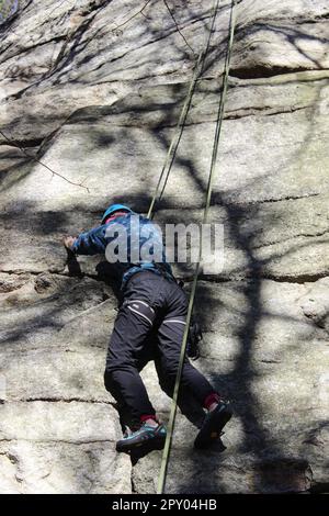 Person latched onto limestone, rock climbing at Peter's Kill in Minnewaska. New Paltz, New York. Stock Photo