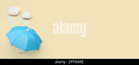 Blue umbrella and cotton clouds on beige background with space for text Stock Photo