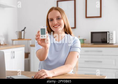 Woman with diabetes measuring blood sugar level at home Stock Photo