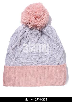 Gray-pink knitted hat with a pom-pom on a white isolated background Stock Photo