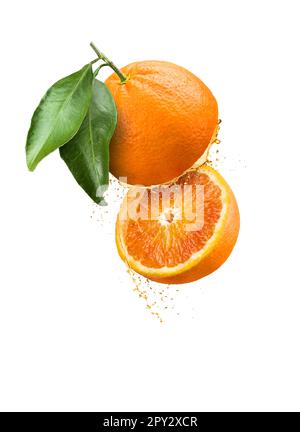 Sliced floating orange fruit with juice drops and leaves, isolated on white background. Stock Photo