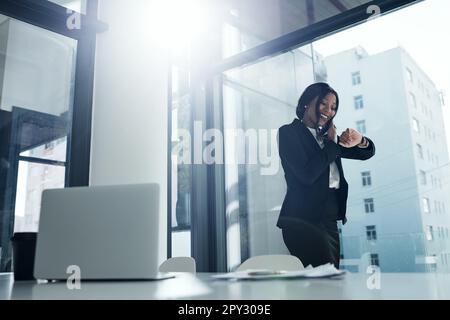 Let your talent do the talking. a young businesswoman using a smartphone and checking the time in a modern office. Stock Photo