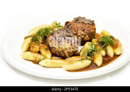 Delicious home cooking: Meatballs with Potato noodles and parsley in hearty gravy Stock Photo