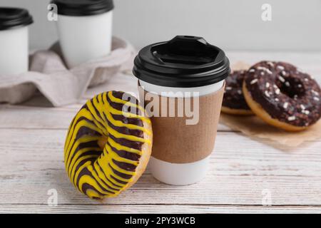 Tasty donut and cup of hot drink on white wooden table Stock Photo