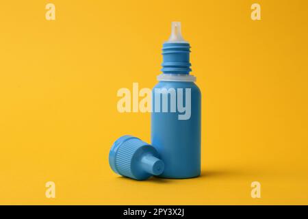 Bottle of medical drops on yellow background Stock Photo