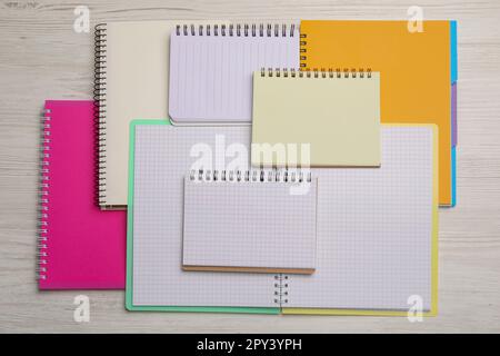Many different notebooks on white wooden table, flat lay Stock Photo