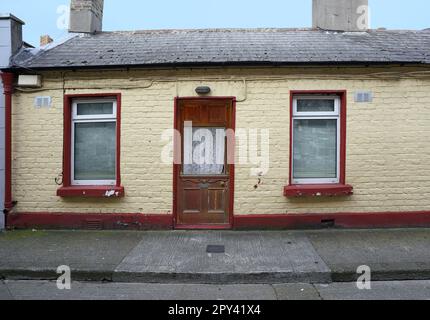 Small one story brick mews house with bricks painted yellow Stock Photo
