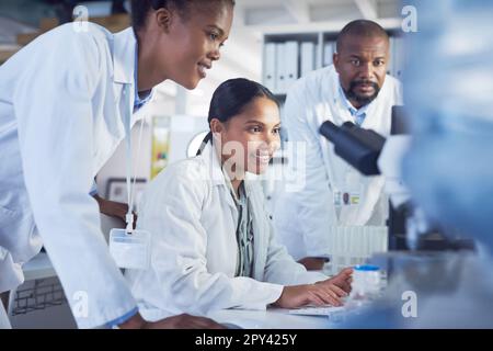 Staying curious about the systems that shape the world. a group of scientists working together in a computer in a lab. Stock Photo
