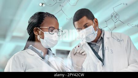 Testing a new formula. two scientists drawing molecular structures on a glass wall in a lab. Stock Photo