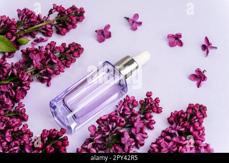 Lilac perfume bottle with spray of lilac flowers on background. creative  floral composition. Close up. Natural perfumery and floral scent concept.  Fresh spring fragrant 8921384 Stock Photo at Vecteezy