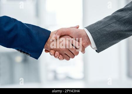 Working with each other to get the best results. Closeup shot of two unrecognisable businesspeople shaking hands in an office. Stock Photo