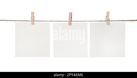 Clothespins with empty notepapers on string against white background. Space for text Stock Photo