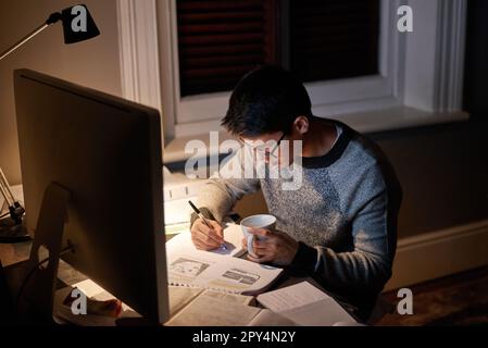 Young, man and student studying at night on a desk computer in a bedroom. College, guy and learning at apartment with coffee to study with technology Stock Photo