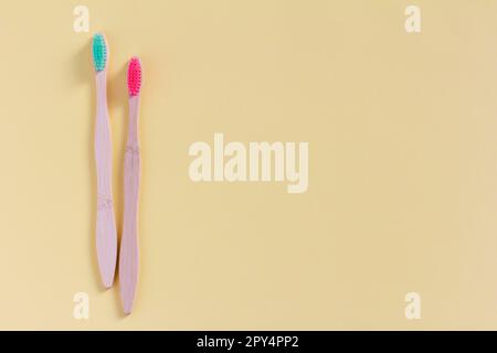 Two toothbrushes made of natural wood on a light beige background, top view. The concept of natural dental care. Space for copying Stock Photo