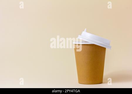 A paper cup for takeaway coffee on a light beige background Stock Photo