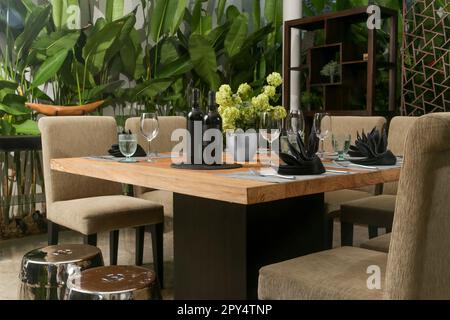 Massive wooden dining table with beautiful flower centerpiece on the balcony Stock Photo